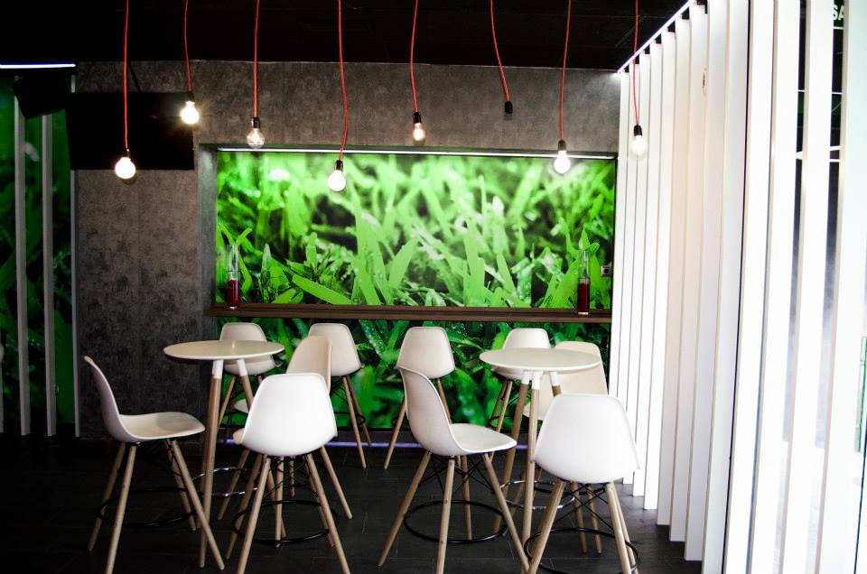 Coffee&Music 14 zona de mesas altas con cesped y lamas verticales con juego de iluminacion